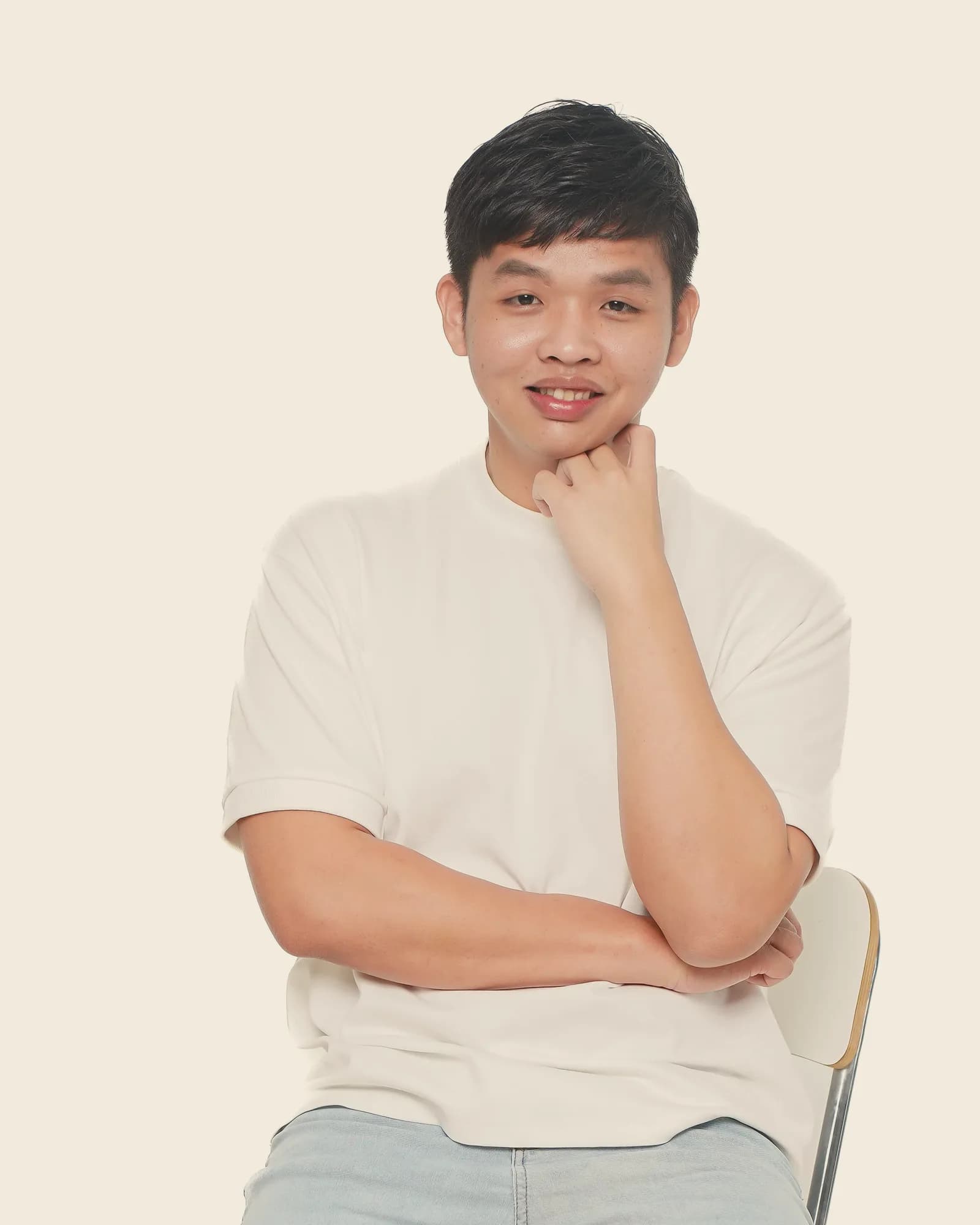Kevin Sheng, smiling, seated with his hand at his chin