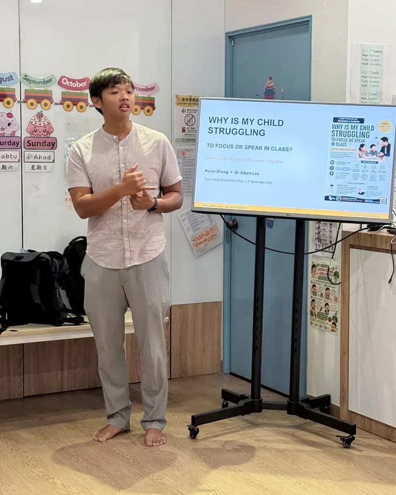 Kevin Sheng speaking beside a slide that reads Why is my child struggling to focus or speak in class